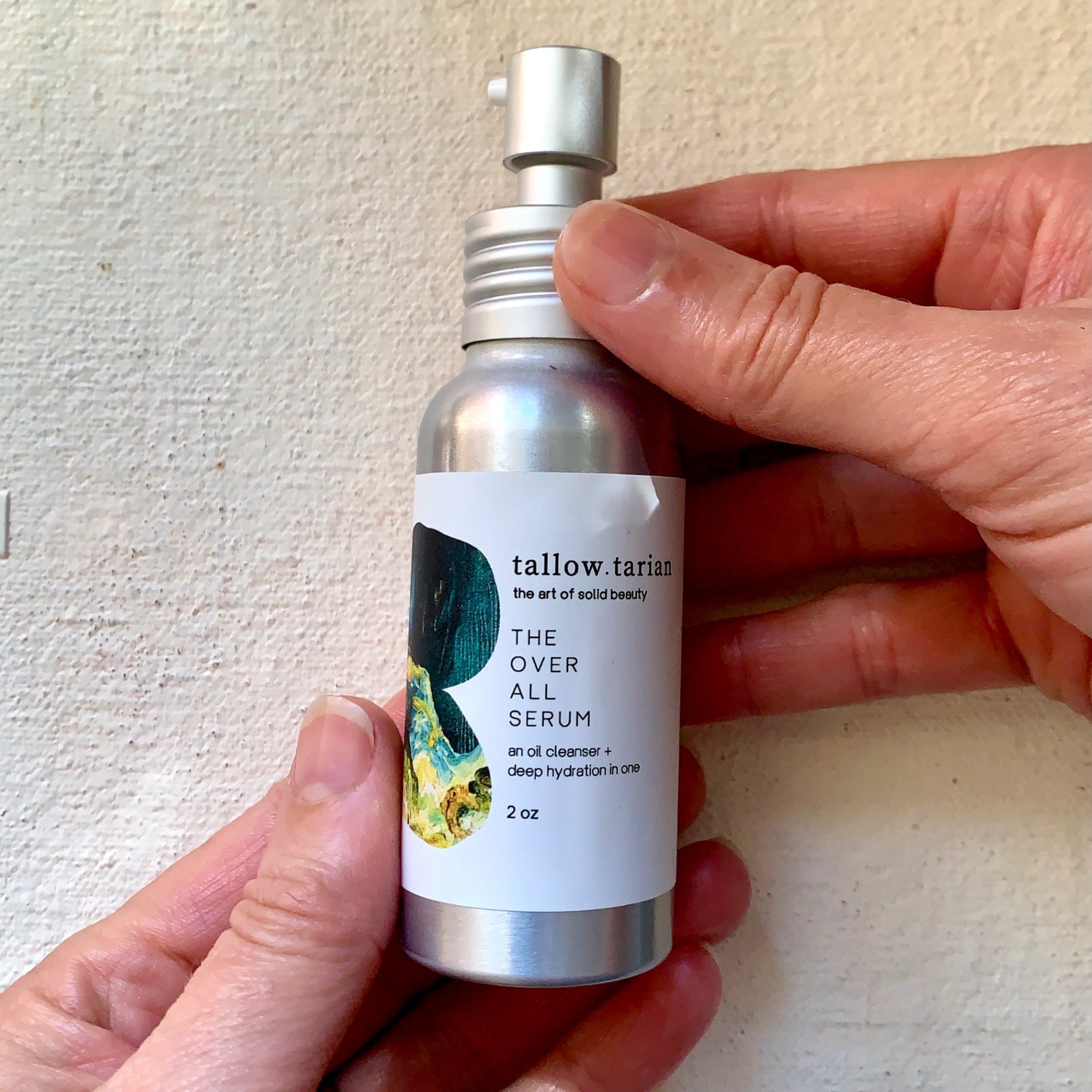 The Over All Serum held in two hands